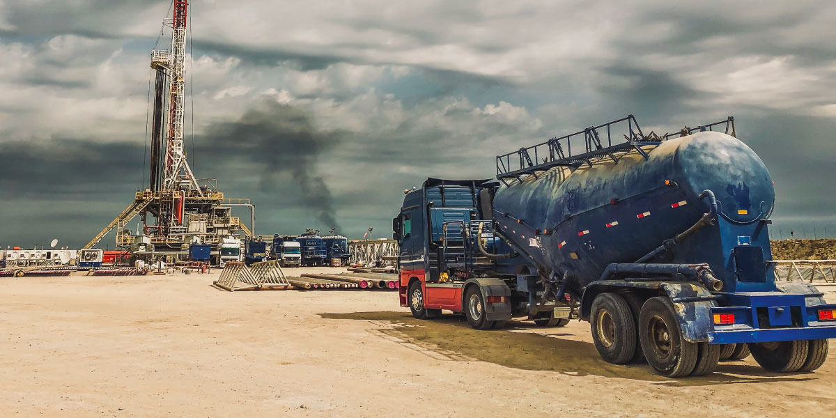 A tanker truck waits for oil from a drilling rig